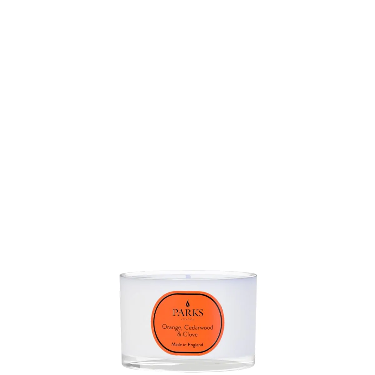 Clear glass candle with an orange label on a white background