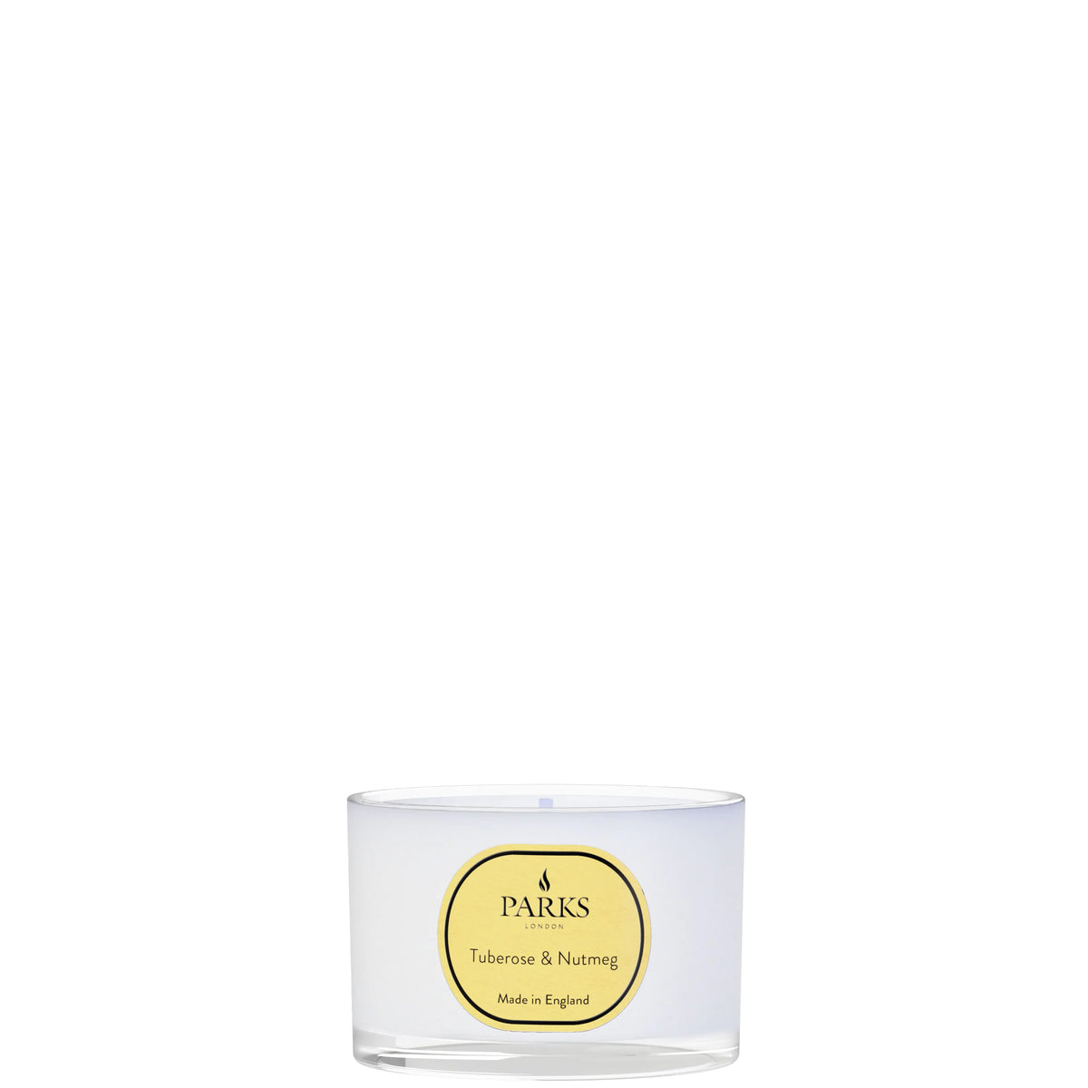 Clear candle in a glass container with a yellow label on a white background