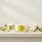 Candle with a 'PARKS' label surrounded by white flowers on a light background