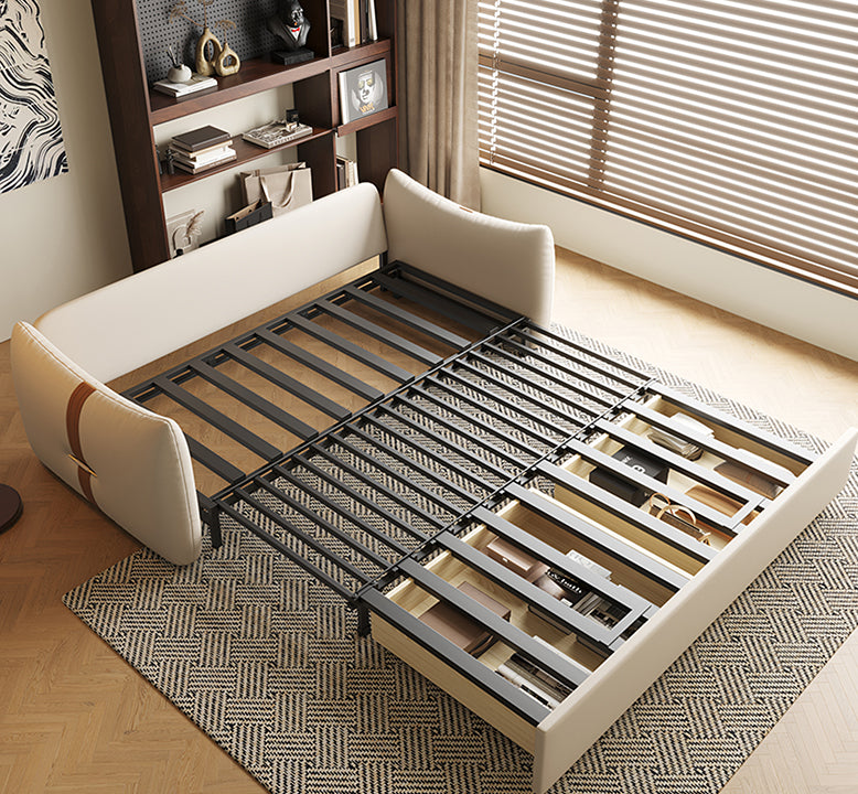 Beige upholstered bed with metal frame in a room with wooden floor and window blinds.