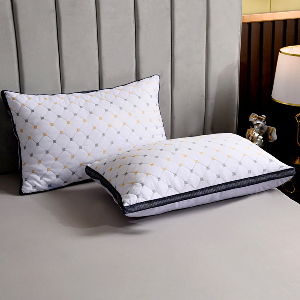 Two pillows with a geometric pattern on a bed in a bedroom setting.