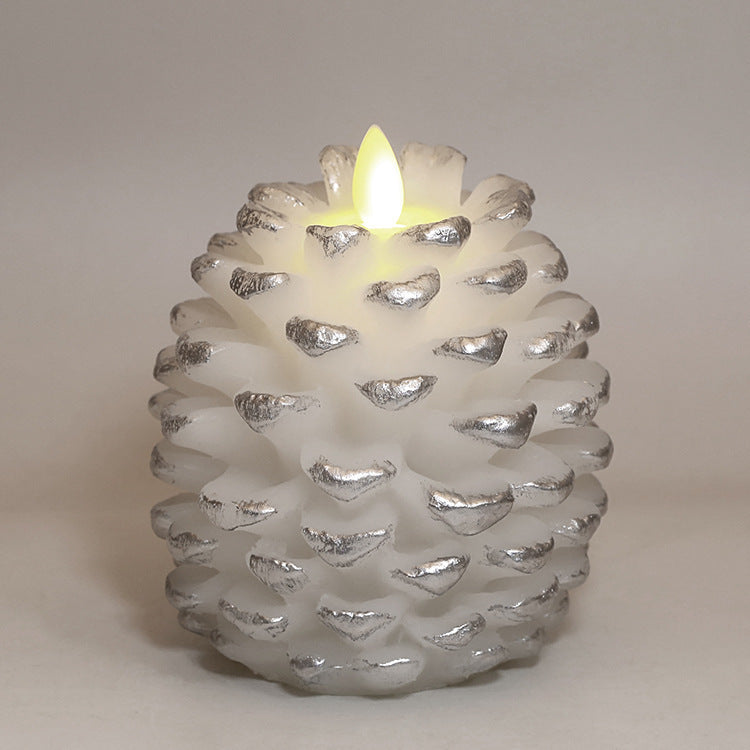 Pine cone-shaped candle with a lit flame on a neutral background