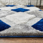 Close-up of a blue and gray geometric patterned rug on a wooden floor.
