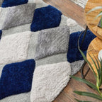 Geometric patterned rug with blue and gray squares on a wooden floor.