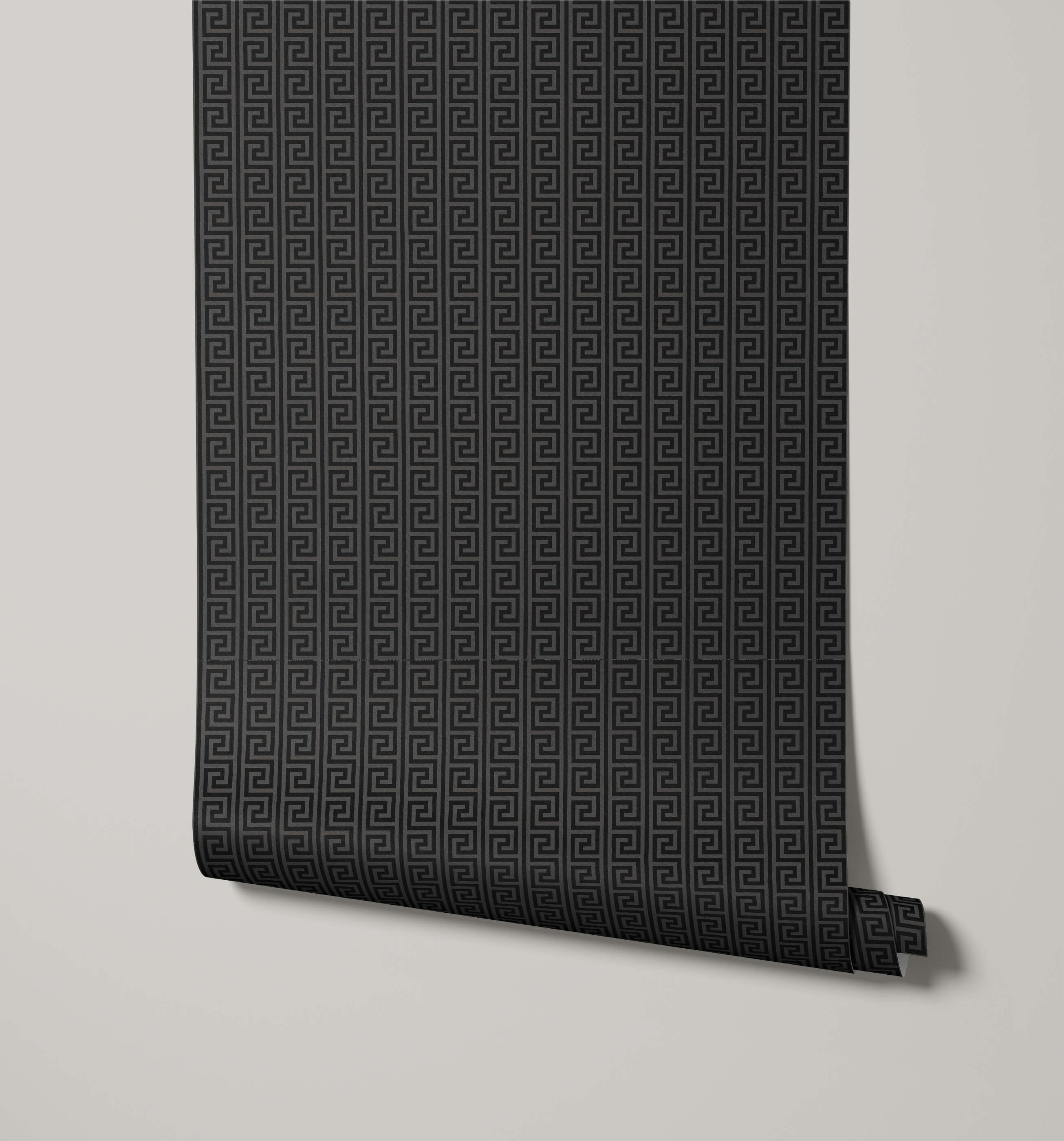 Roll of black geometric patterned wallpaper on a light gray background