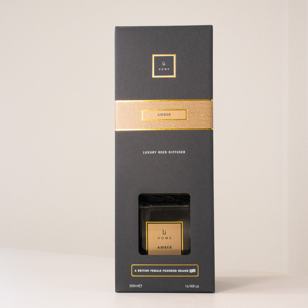 Black and gold box with a candle inside on a white background