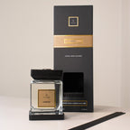 Candle and packaging with gold accents on a neutral background