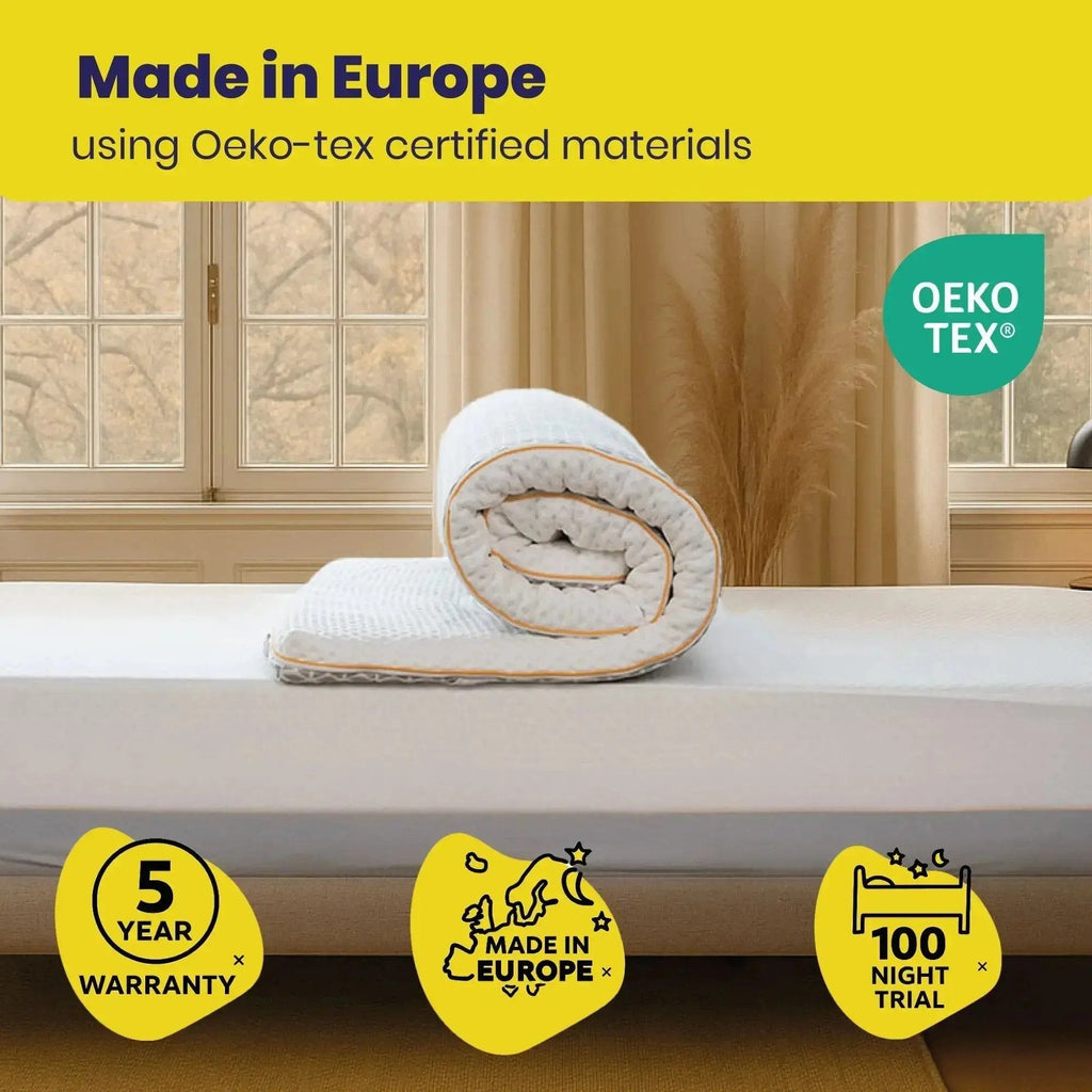 Roll of mattress topper on a bed with 'Made in Europe' and Oeko-Tex certification text.