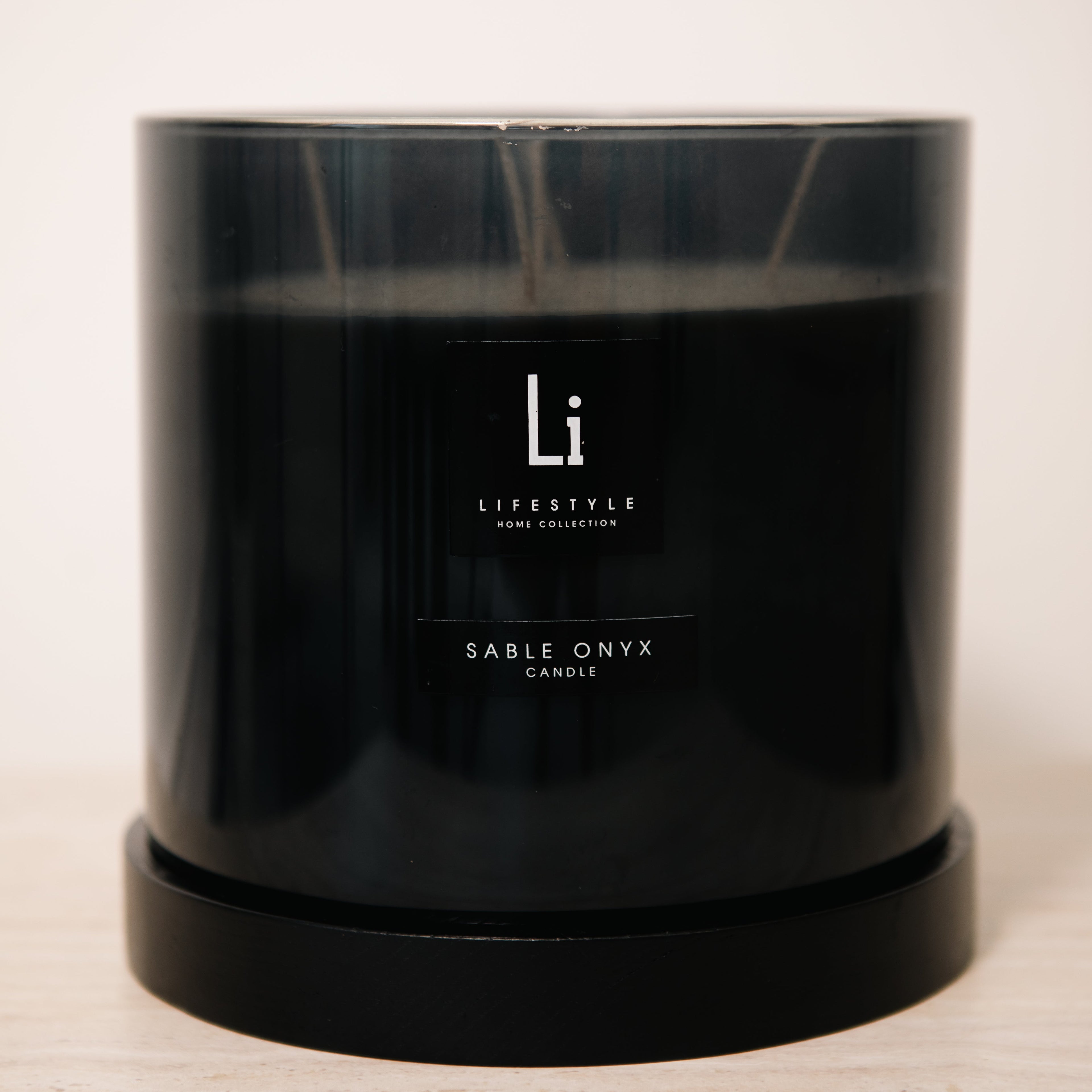 Black candle with 'Li Lifestyle' branding on a light background