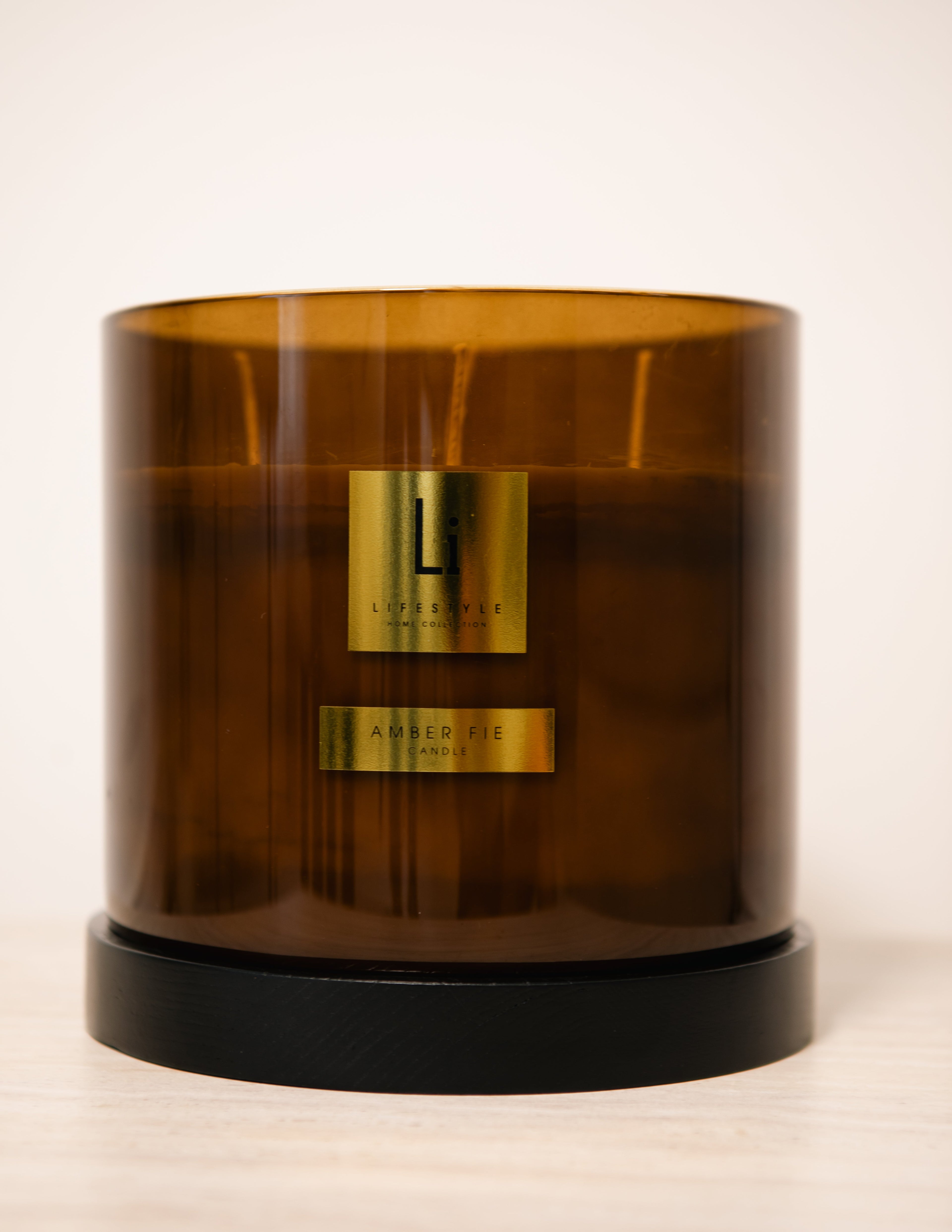 Brown candle with gold labels on a white background