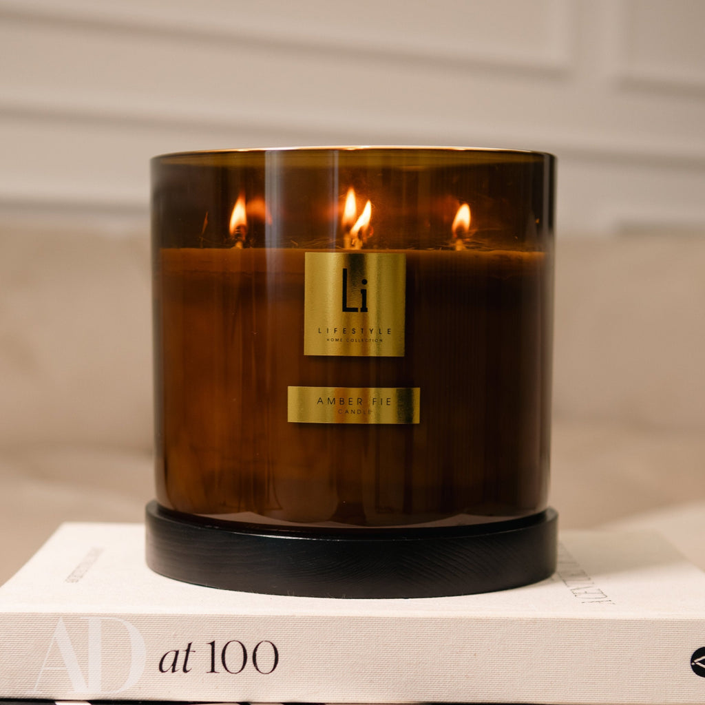 Brown candle with a visible brand logo on a beige surface