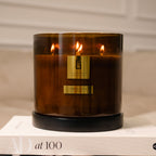 Brown candle with a visible brand logo on a beige surface