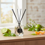 Diffuser with black sticks on a wooden surface with limes and oranges