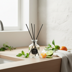Diffuser with black sticks on a wooden surface with fruits and plants