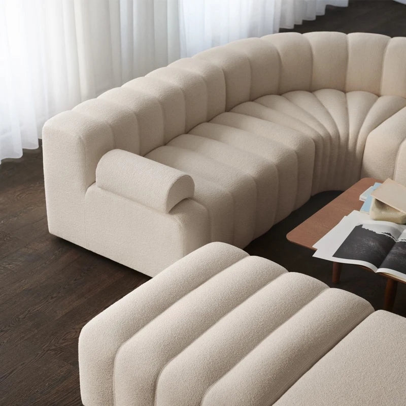 Beige sectional sofa in a living room setting with a wooden coffee table.