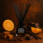 Diffuser with reeds, oranges, chocolate, and coffee beans on a dark background