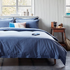 Bedroom with blue bedding and a wooden nightstand.