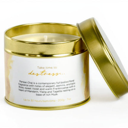 Candle in a gold and white tin with a label on a white background