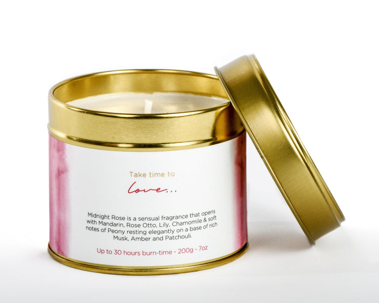 Candle in a gold tin with a white label on a white background