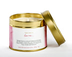 Candle in a gold tin with a white label on a white background