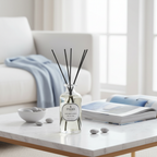 Diffuser bottle on a coffee table with a couch and window in the background