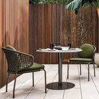 Outdoor patio set with two chairs and a table against a wooden fence.