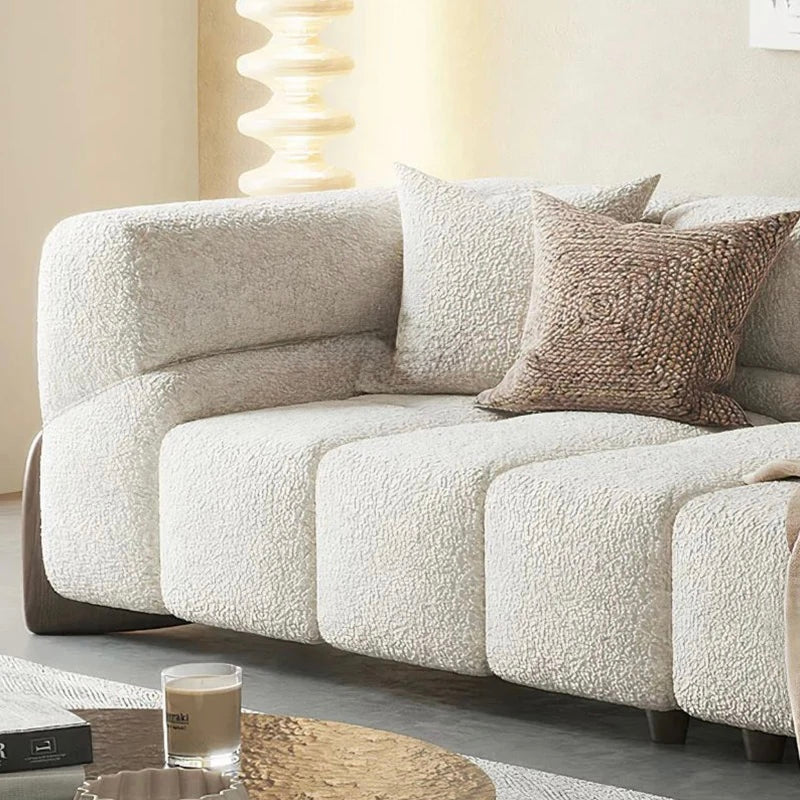 Beige textured sofa with decorative pillows in a living room setting.