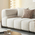 Beige textured sofa with decorative pillows in a living room setting.