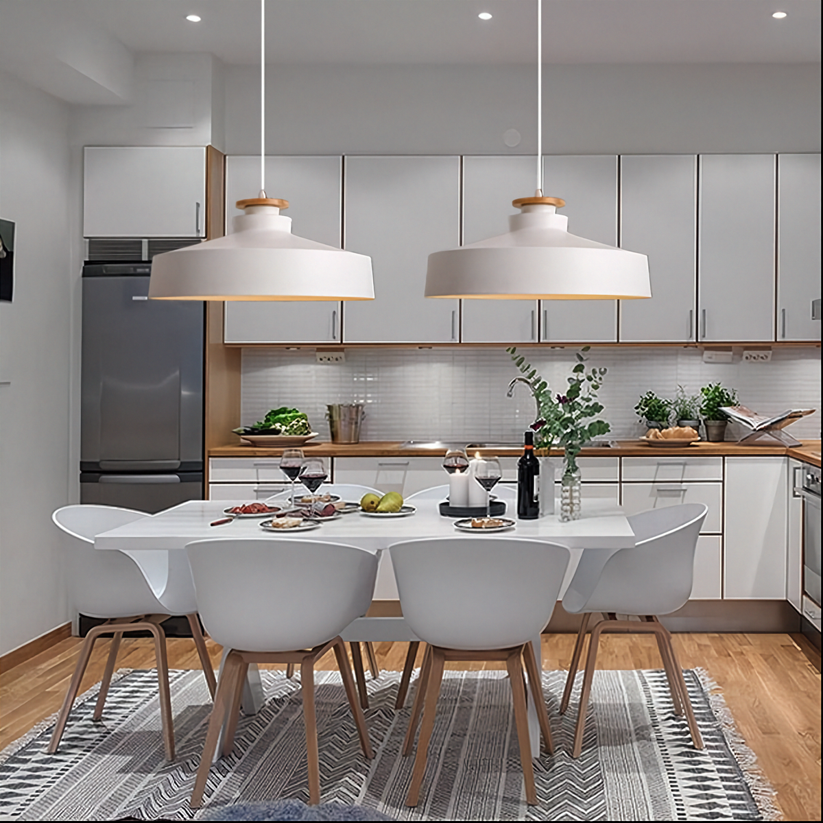 Modern kitchen with dining area featuring a white table and chairs.
