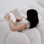 Person reading a book on a white textured surface