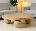Wooden coffee table with spherical bases in a living room setting