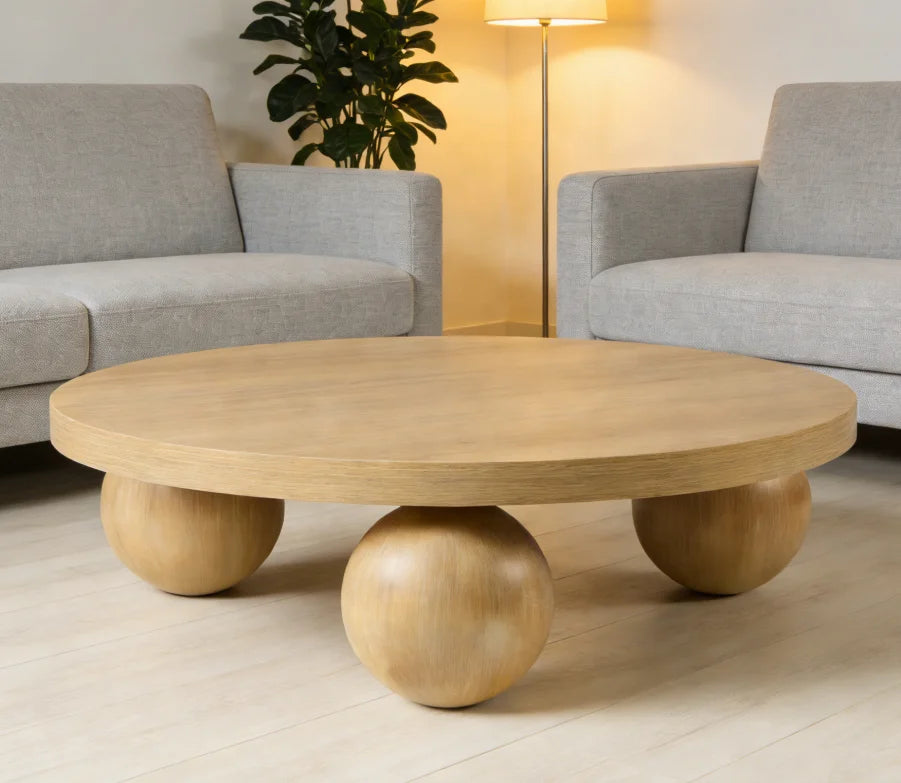 Wooden coffee table with spherical bases in a living room setting