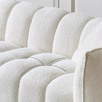 Close-up of a textured white sofa with visible stitching details.