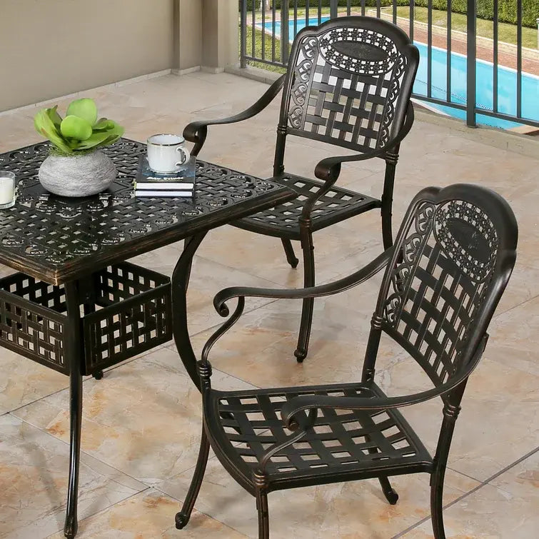 Outdoor patio set with two chairs and a table by a poolside.