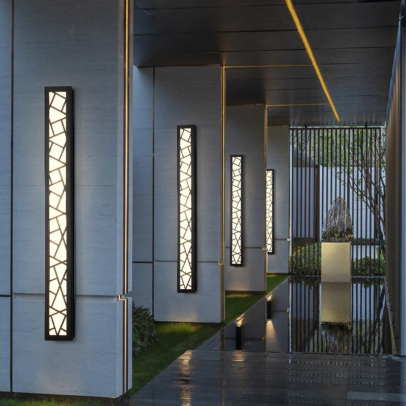 Modern outdoor wall lights on a building exterior with a reflective surface and garden view.