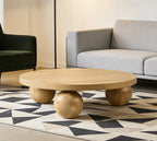Wooden coffee table with spherical bases in a living room setting