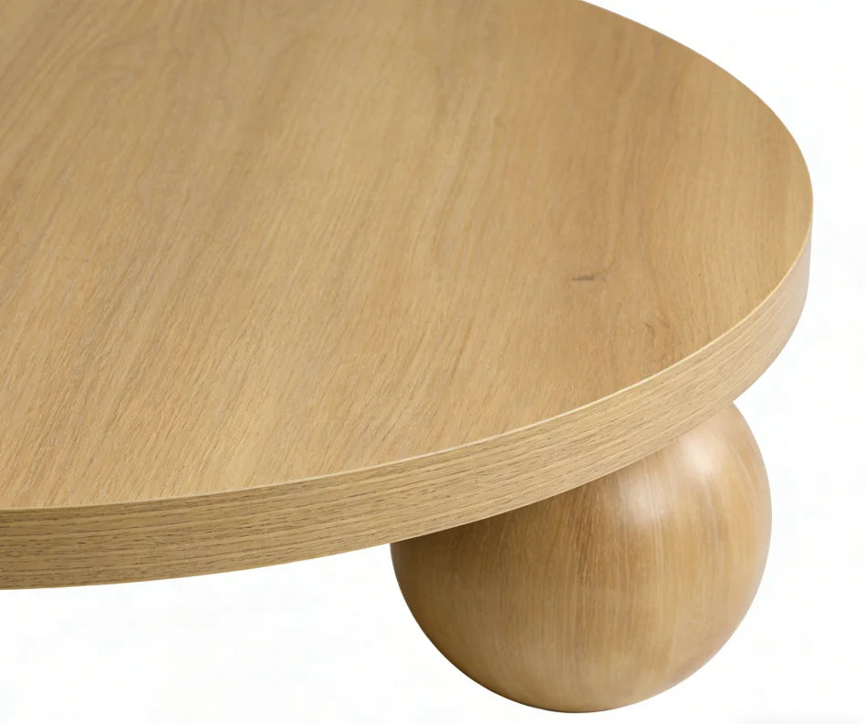 Wooden table with a round top and spherical base on a white background