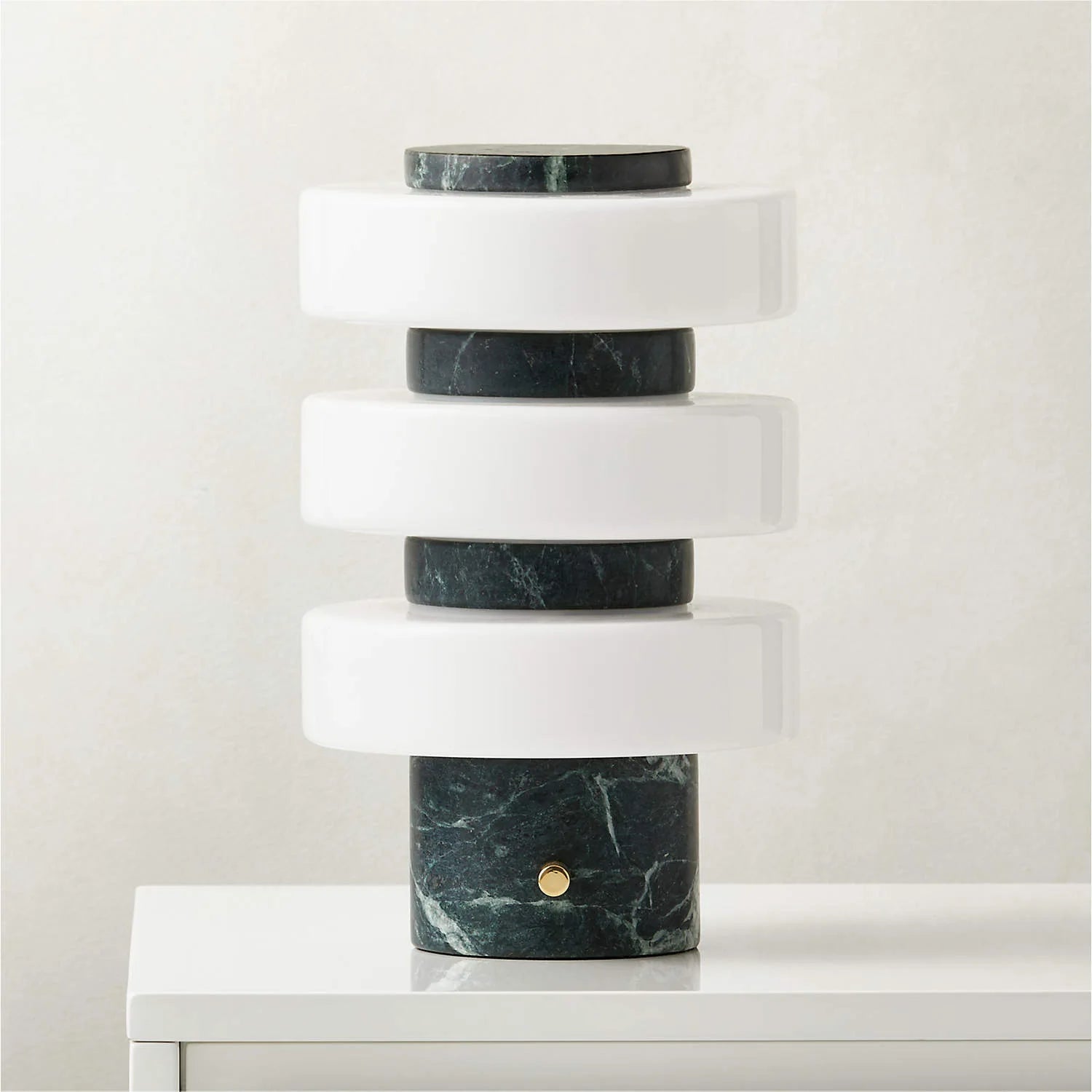 Modern table lamp with marble base and cylindrical design on a white surface.
