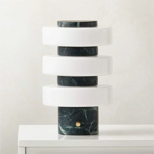 Modern table lamp with marble base and cylindrical design on a white surface.