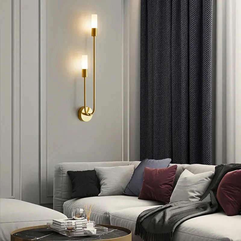 Modern living room with a sectional sofa, wall sconces, and dark curtains.