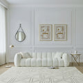 White sofa in a living room with decorative mirrors and rugs.