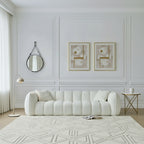White sofa in a living room with decorative mirrors and rugs.