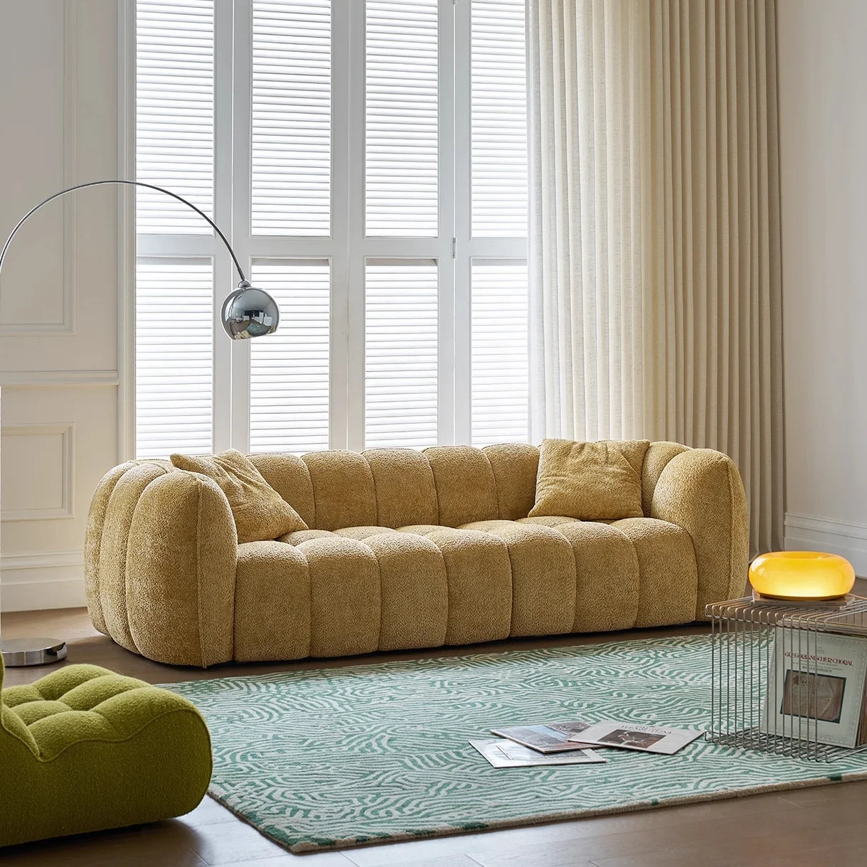 Modern living room with a beige sofa, glass coffee table, and decorative items.