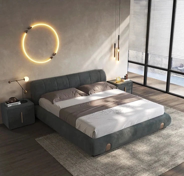 Modern bedroom with a gray upholstered bed, nightstands, and decorative lighting.