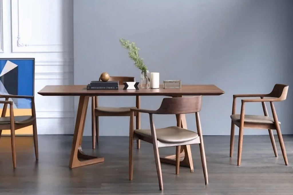 Dining table set with chairs in a room with a gray wall and wooden floor.