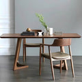 Wooden dining table with chairs in a minimalistic room.