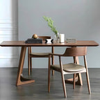 Wooden dining table with chairs in a minimalistic room.