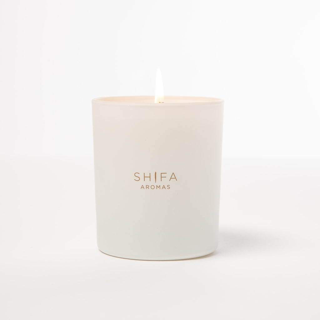 White candle with 'SHIFA AROMAS' branding on a white background