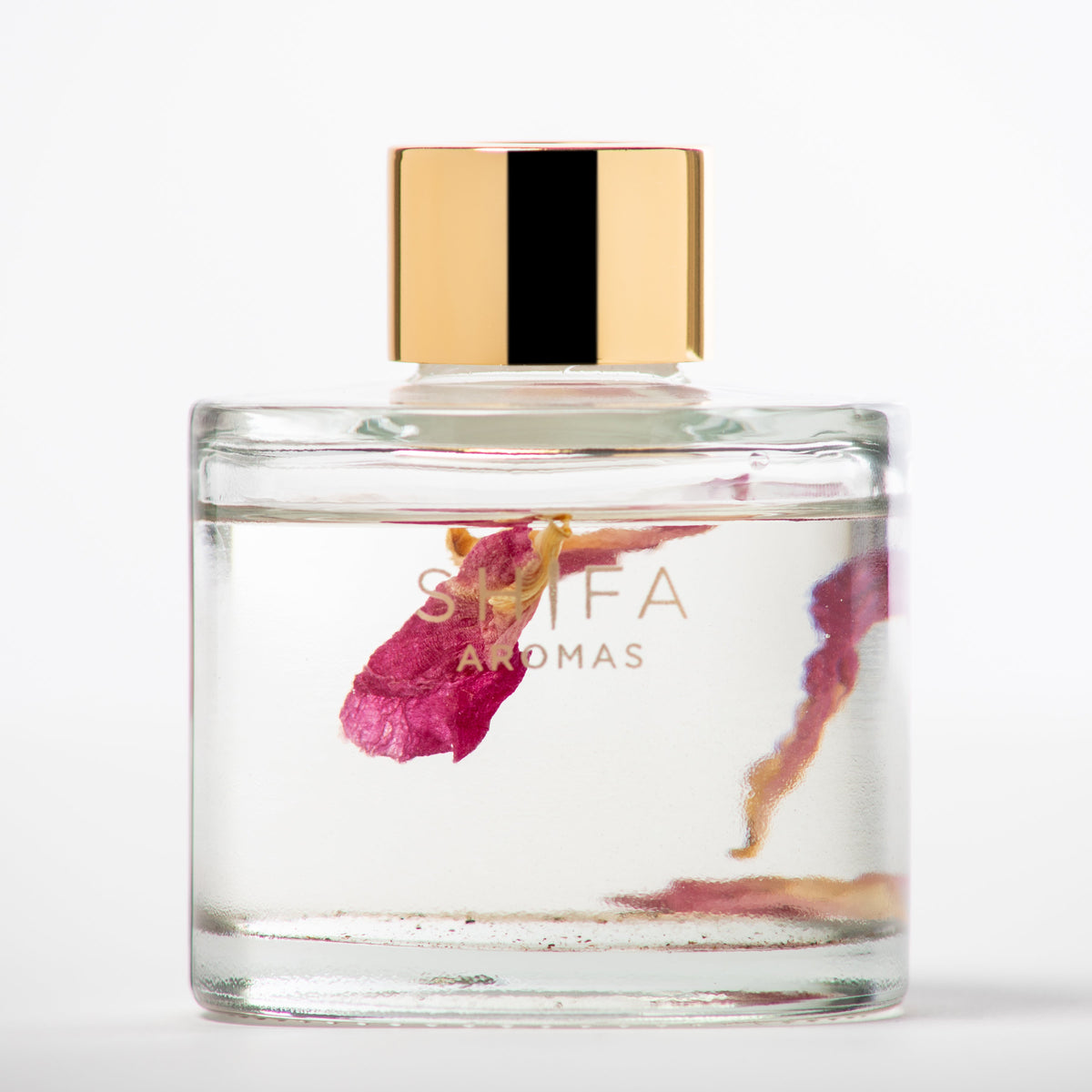 Perfume bottle with gold cap and floral design on a white background