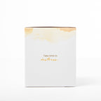 White candle box with gold text and design on a white background